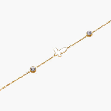 Gold chain bracelet with white mother of pearl butterfly pendant and two bezel-set crystals on cream background